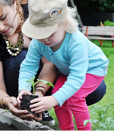 Ein Kind pflanzt ein Stöckchen ein